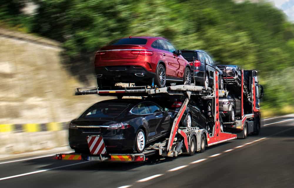 A truck hauling cars down a highway